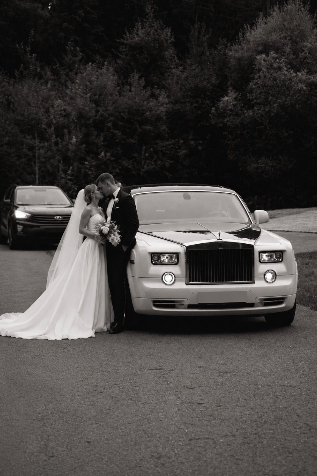 Bride and groom beside a white Rolls-Royce Phantom