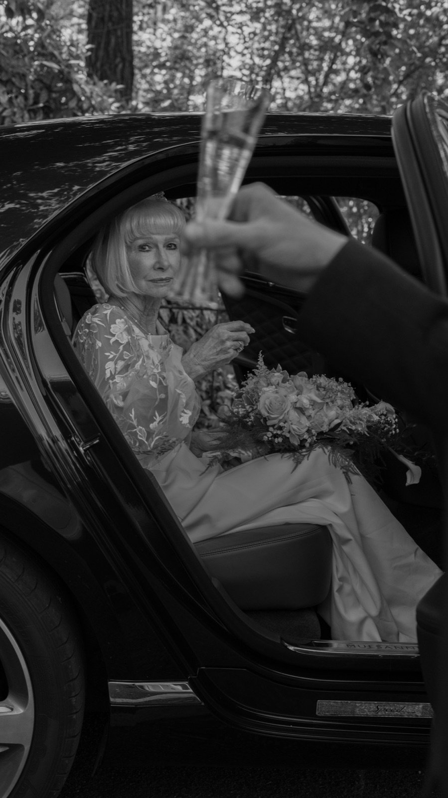 Bride toasting champagne in a Bentley Mulsanne